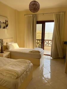 sypialnia z 2 łóżkami i balkonem w obiekcie Gravity Joy Apartments Sahl Hasheesh w mieście Hurghada