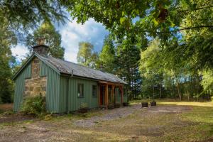 a green building in the middle of a forest at Kerrow House in Cannich