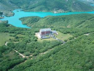 an aerial view of a building on a hill next to a lake at Parador de Cervera de Pisuerga in Cervera de Pisuerga