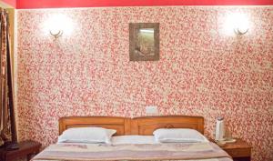 Un pat sau paturi într-o cameră la Goroomgo Shambhu Mall Road Darjeeling
