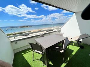 einen Balkon mit Tisch und Stühlen sowie Strand in der Unterkunft Loriot2 - appartement vue sur mer in Ploemeur + 19 Fotos