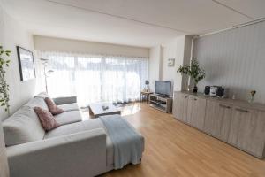 a living room with a couch and a tv at Appartement Hoek in Giethoorn