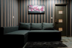 un divano in una stanza con un dipinto sul muro di Mavie Apartment Boutique a Bucarest