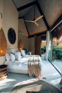 um quarto com uma cama e uma ventoinha de tecto em Hotel Muaré & Spa Tulum em Tulum