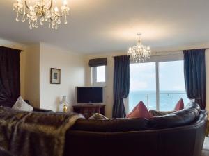 a living room with a couch and a large window at Seaview Apartment - 21 Spinnakers in Newquay