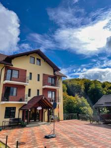 a large building with a brick patio in front of it at Pensiunea 7 Brazi II in Poiana Mărului +59 photos