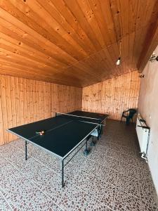 a ping pong table in a room with a wooden ceiling at Pensiunea 7 Brazi in Poiana Mărului