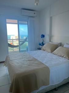 um quarto com uma cama grande e uma janela grande em Apartamento Barra Sky Vista Mar em Salvador