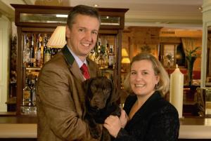a man and a woman holding a dog in a bar at Superior Hotel Tirolerhof - Zell am See in Zell am See +37 photos