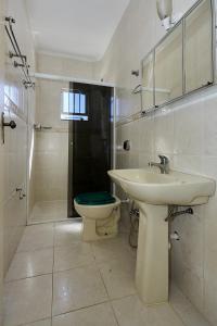 une salle de bain blanche avec un lavabo et des toilettes dans l'établissement 1040 - Departamento 2 quartos na Rua Pirajica . 200 m da Praia Bombinhas Centro, à Bombinhas 20 autres photos