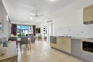 a kitchen and living room with a table and chairs at City Quays Accommodation in Cairns