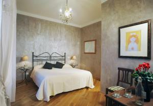 ein Schlafzimmer mit einem großen weißen Bett und einem Kronleuchter in der Unterkunft Sweet Dreams in St Peter B&b in Rom
