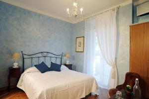 a bedroom with a bed with blue walls and a chandelier at Sweet Dreams in St Peter B&b in Rome