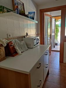 uma cozinha com um balcão branco e um micro-ondas em Precioso apartamento con piscina comunitaria privada y patio exterior em Ayamonte