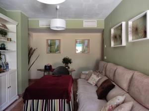 uma sala de estar com um sofá e uma mesa em Precioso apartamento con piscina comunitaria privada y patio exterior em Ayamonte