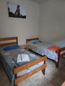 two beds sitting in a room with at Pousada Serra Carioca Friburgo in Nova Friburgo
