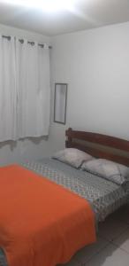 a bedroom with a bed with an orange blanket at Pousada Serra Carioca Friburgo in Nova Friburgo