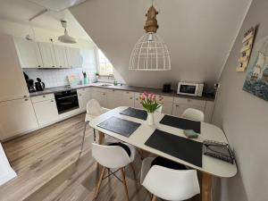 uma cozinha com uma mesa e cadeiras numa cozinha em Place to be Fehmarn em Fehmarn