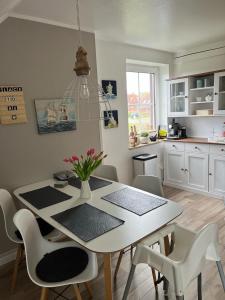 cocina con mesa blanca y sillas y comedor en Place to be Fehmarn en Fehmarn