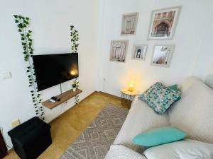 Corazón De Córdoba, la mejor ubicación في قرطبة: غرفة معيشة مع أريكة وتلفزيون بشاشة مسطحة