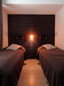 um quarto com 2 camas e uma parede com luz em Levin Kolmio C2 em Levi