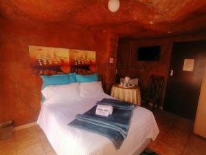 Sikhula Sonke Guest House في برونكهورستسبرويت: غرفة نوم مع سرير في غرفة حجرية