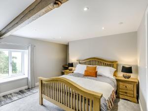 a bedroom with a wooden bed and a window at Upper Bryn Y Groes in New Bridge