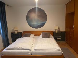 twee bedden in een kamer met een schilderij aan de muur bij Ruhige Ferienwohnung in der Stadtmitte in Hadamar