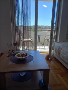 un plato de comida en una mesa en una habitación con balcón en Apartman Magdalena, en Trebinje