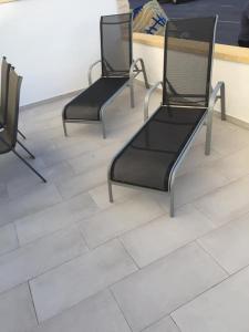 three black chairs sitting on a tile floor at Charmant rez-de-chaussée et piscine bar-restaurant in Alicante