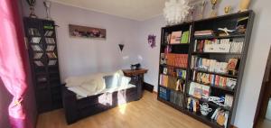 a room with a book shelf filled with books at Chambre des Acacias 