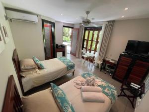 a hotel room with two beds and a television at The Haven - Hotel & Spa, Health and Wellness Accommodation - Adults Only in Boquete