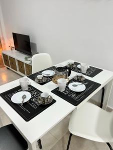 a white table with plates and bowls on it at Fuengirola Paseo Marítimo 27 in Fuengirola