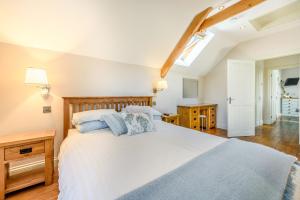 a bedroom with a large bed and a skylight at Ysgubor Isaf in Troedyraur