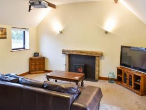 a living room with a couch and a fireplace at Swallow Cottage in Howden