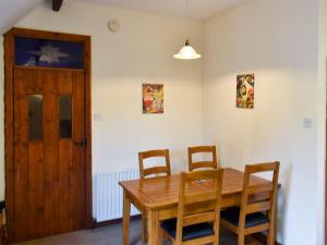 a dining room with a wooden table and chairs at Swallow Cottage in Howden