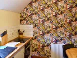 a kitchen with a colorful wallpaper on the wall at Swallow Cottage in Howden