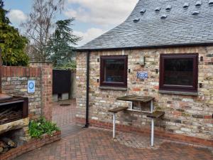 a brick building with two windows and a grill at Swallow Cottage in Howden