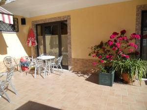 a patio with a table and chairs and flowers at Albergo Maria Cristina in Esperia +3 photos