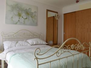 Schlafzimmer mit einem weißen Bett und einem Spiegel in der Unterkunft Atlas And Pearl in South Hayling