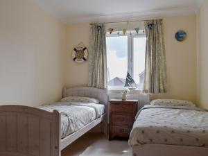 2 Einzelbetten in einem Schlafzimmer mit Fenster in der Unterkunft Atlas And Pearl in South Hayling