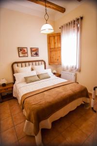 ein Schlafzimmer mit einem großen Bett und einem Fenster in der Unterkunft Colonia Apartamento Rural in Bellmunt de Ciurana