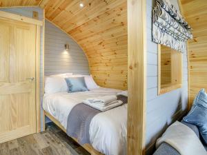 a bedroom with a bed in a wooden cabin at Barcud- UK37574 in Llanboidy