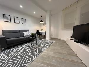 a living room with a couch and a television at Apartamento Villamediana Suite in Villamediana de Iregua