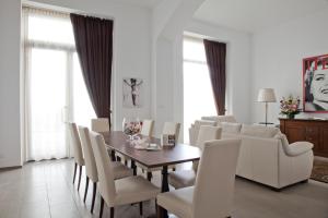a dining room with a table and white chairs at Santa Giulia Hotel e Residence Torino in Turin