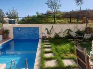 a backyard with a swimming pool and a garden at Stylish two bedroom house with private pool in Tirana