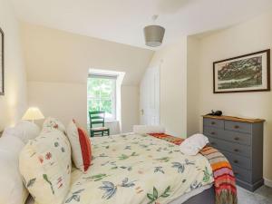 a bedroom with a bed and a dresser and a window at New Cottage in Farr