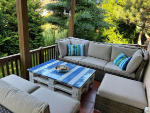 a porch with a couch and a coffee table at Bosio nad morze in Sztutowo