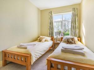 two twin beds in a room with a window at The Poplars in Catwick