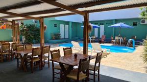 a patio with tables and chairs and a swimming pool at Tamandaré Praia Hotel in Tamandaré